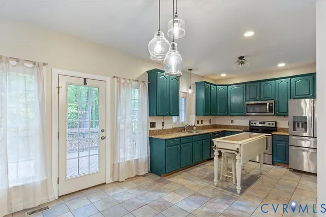 a kitchen with stainless steel appliances granite countertop a stove top oven a sink dishwasher and a refrigerator