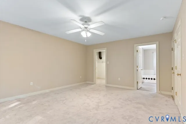 an empty room with closet and fan