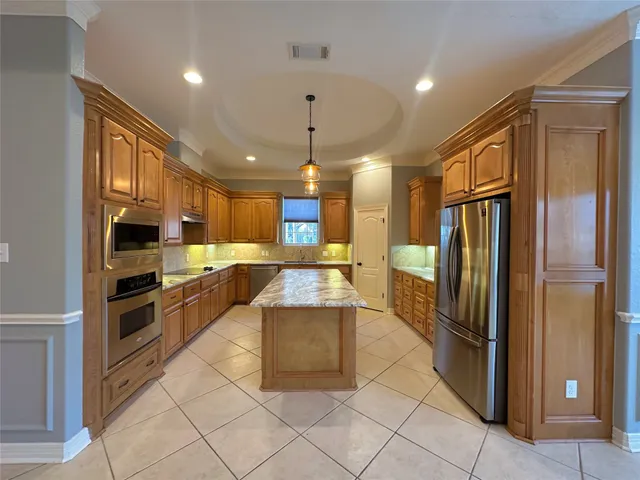a kitchen with stainless steel appliances granite countertop a refrigerator a sink and a stove