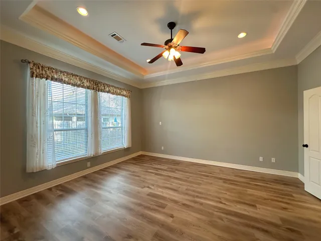 a view of an empty room with a kitchen and a window