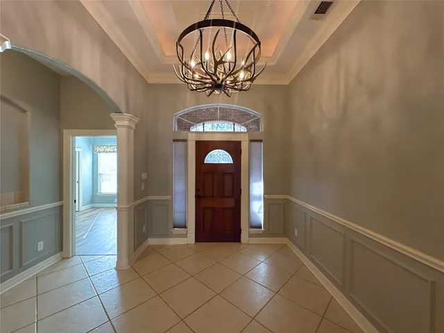 a view of a hallway with wooden floor and a living room