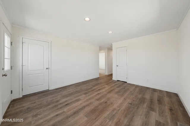 a view of an empty room with wooden floor