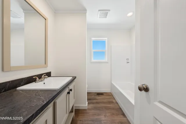 a spacious bathroom with a granite countertop sink and a mirror