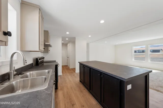 a kitchen with a sink cabinets and wooden floor