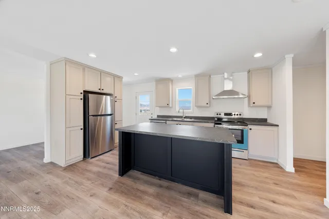 a kitchen with stainless steel appliances granite countertop a refrigerator and a stove top oven
