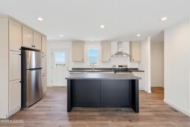 a large kitchen with stainless steel appliances granite countertop a refrigerator and a sink