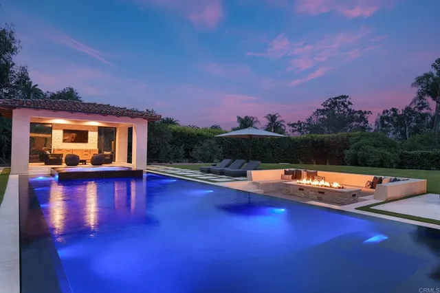 a view of swimming pool with lounge chair and fire pit