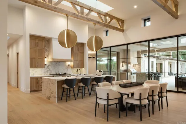a view of a dining room and livingroom with furniture a rug and a large mirror