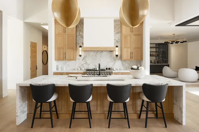 a kitchen with a dining table chairs sink and cabinets