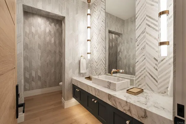 a bathroom with a granite countertop sink a mirror and shower