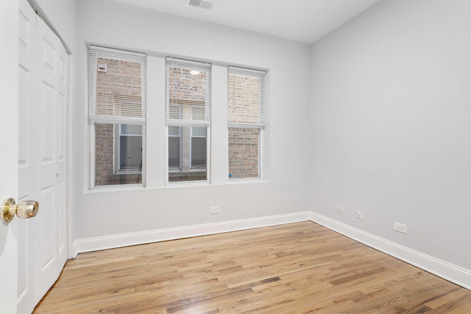 7322 North Damen Avenue, Unit 3 Chicago, IL 60645 - Photo 9 of 16 a view of an empty room with wooden floor and a window