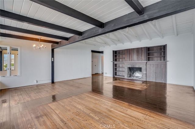 a view of a room with wooden floor and windows