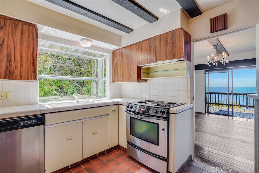 1811 Ocean Way Laguna Beach, CA 92651 - Photo 6 of 28 a kitchen with stainless steel appliances granite countertop a stove a sink and a microwave