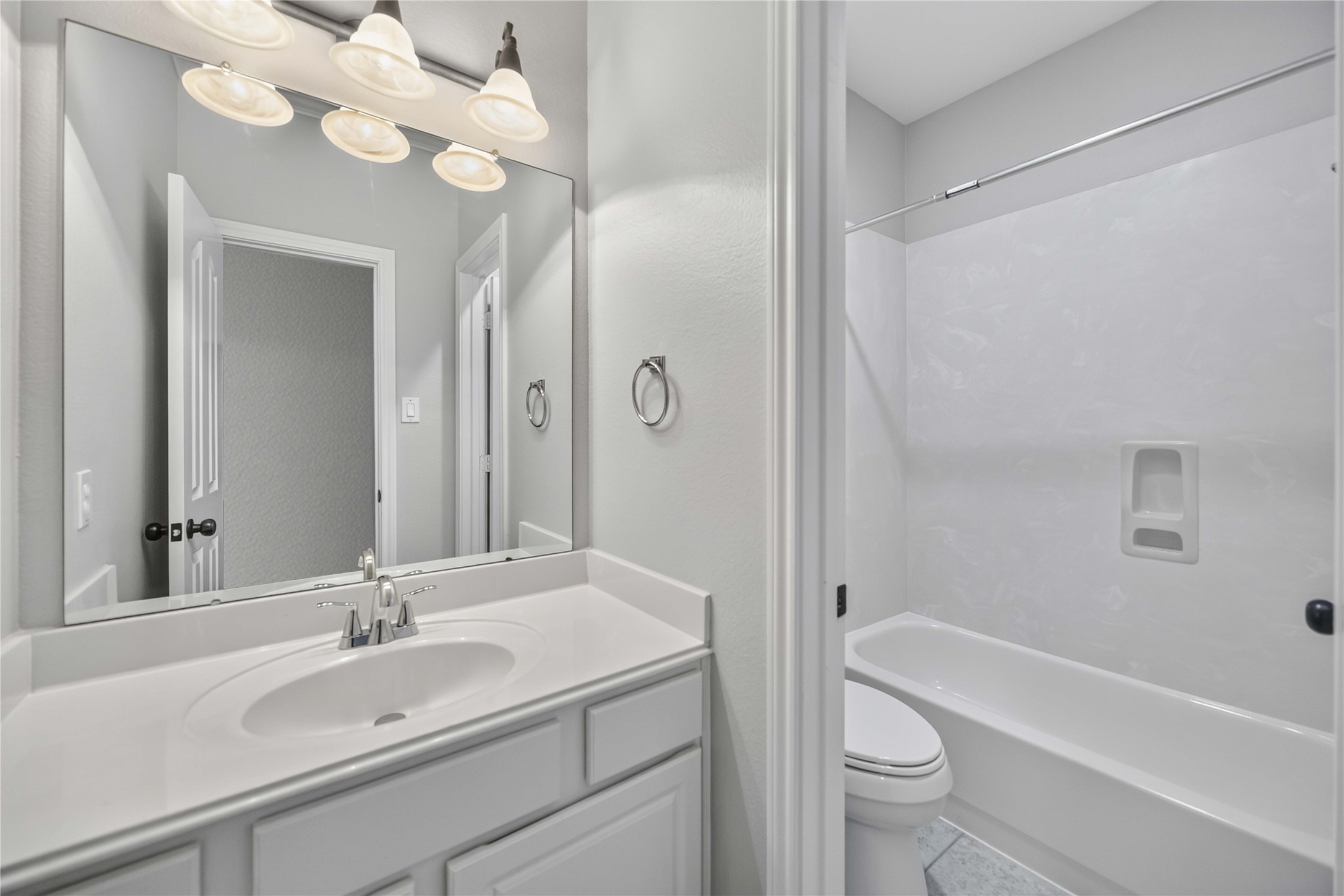 3303 Raleigh Row Missouri City, TX 77459 - Photo 33 of 50 Bright and modern bathroom featuring a sleek vanity with ample counter space, complemented by elegant lighting and a pristine shower-tub combination.