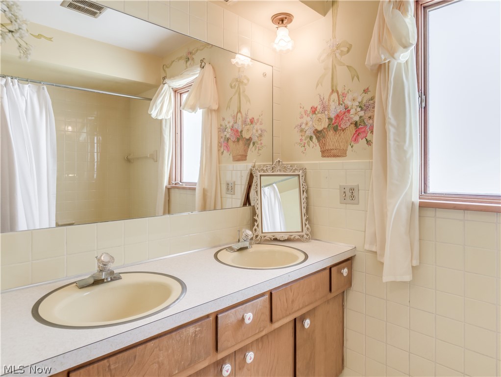 2481 Raber Road Uniontown, OH 44685 - Photo 23 of 33 Main Bathroom with dual sinks, tub/shower combo and linen closet