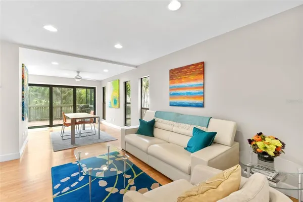 a living room with a floor to ceiling window and wooden floor