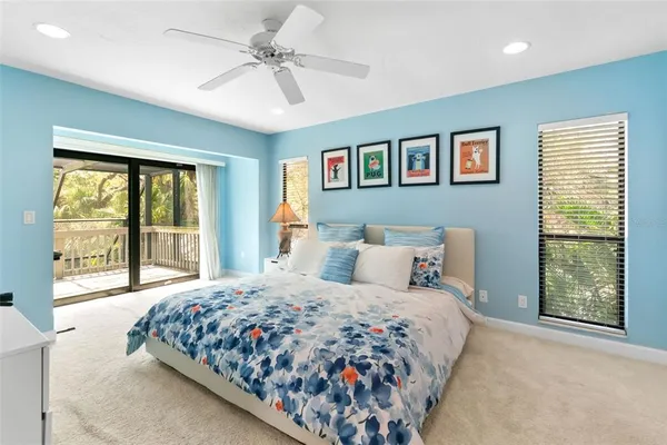 a bedroom with a bed and a large window with wooden floor