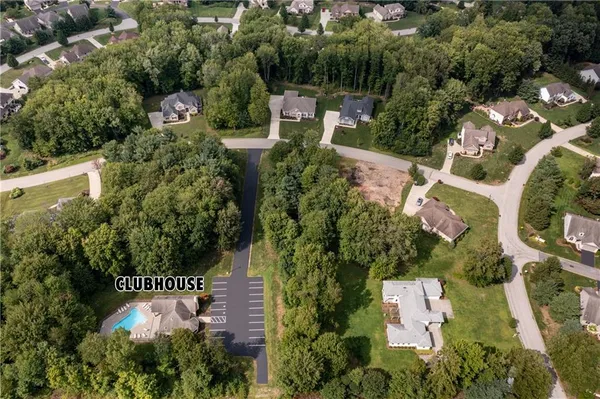 an aerial view of residential house with outdoor space and trees all around