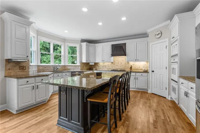 a kitchen with stainless steel appliances granite countertop a stove refrigerator and cabinets