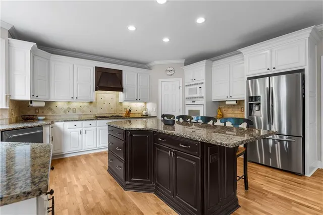 a kitchen with granite countertop white cabinets and white appliances