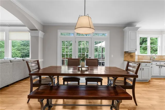 a view of a dining room and livingroom with furniture wooden floor a rug a chandelier