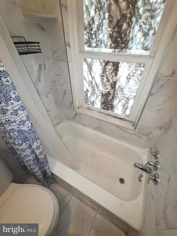 a bathroom with a bathtub and window