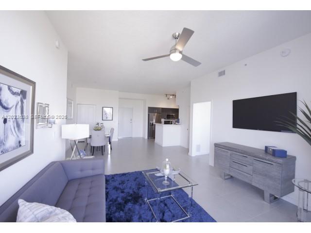 729 Northwest 2nd Street, Unit 920 Miami, FL 33128 - Photo 3 of 9 a living room with furniture and a flat screen tv