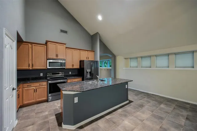 a kitchen with stainless steel appliances granite countertop a sink stove and refrigerator