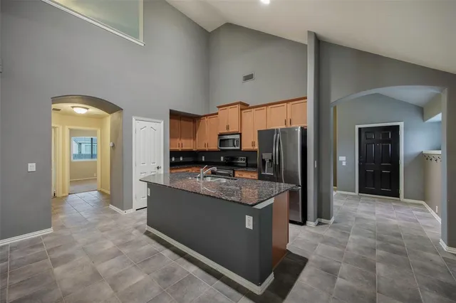 a kitchen with stainless steel appliances granite countertop a refrigerator and a stove