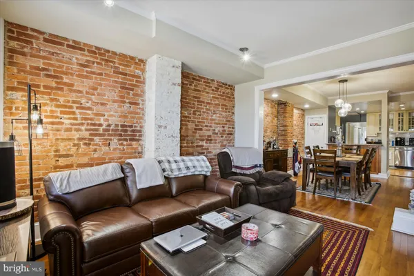 a living room with furniture wooden floor and a floor to ceiling window