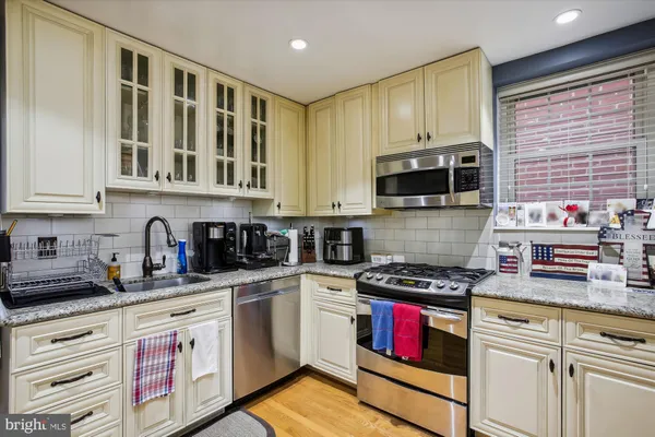 a kitchen with stainless steel appliances granite countertop a stove a sink and a microwave