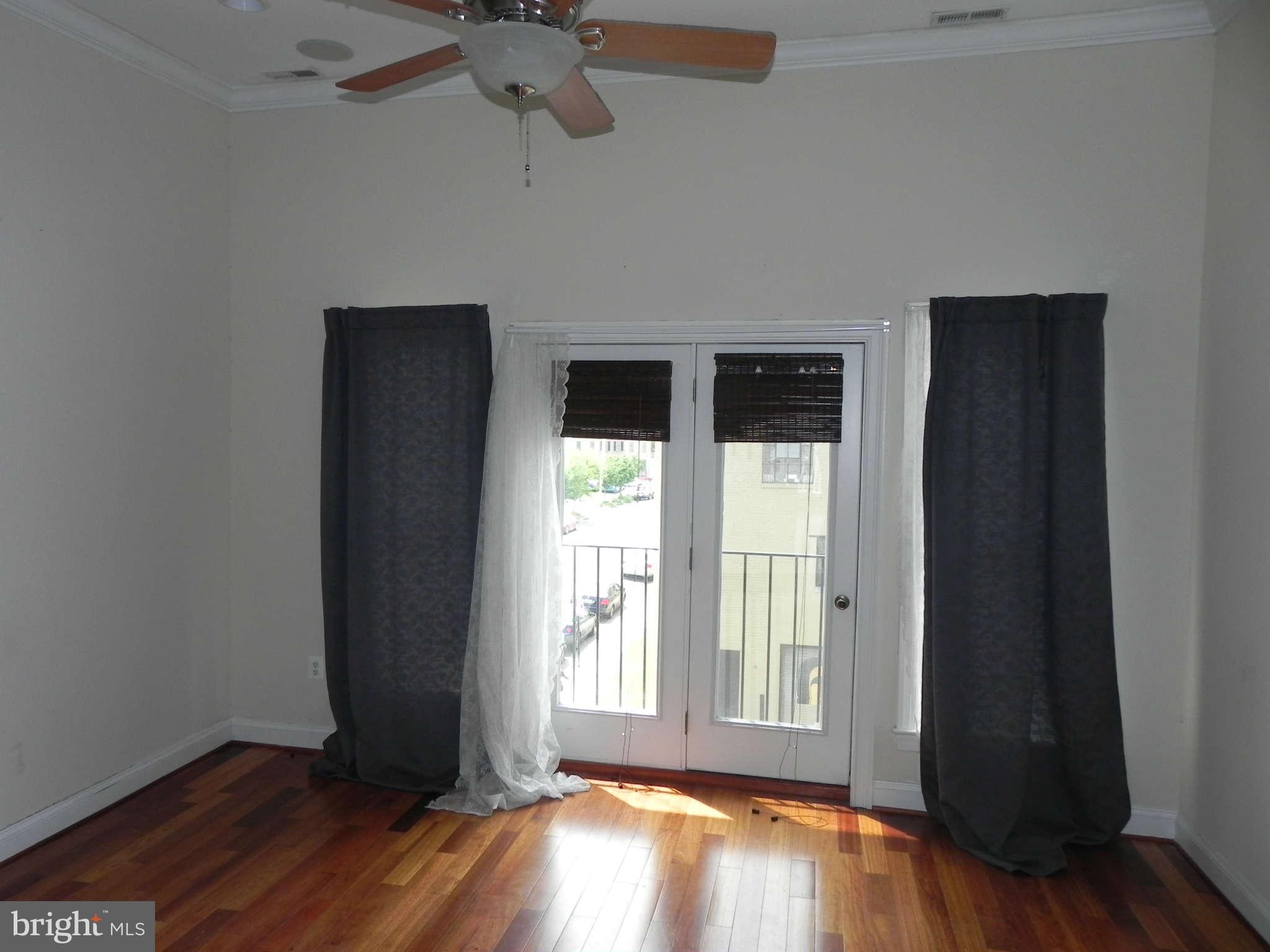 106 West Cross Street Baltimore, MD 21230 - Photo 22 of 29 an empty room with wooden floor and windows