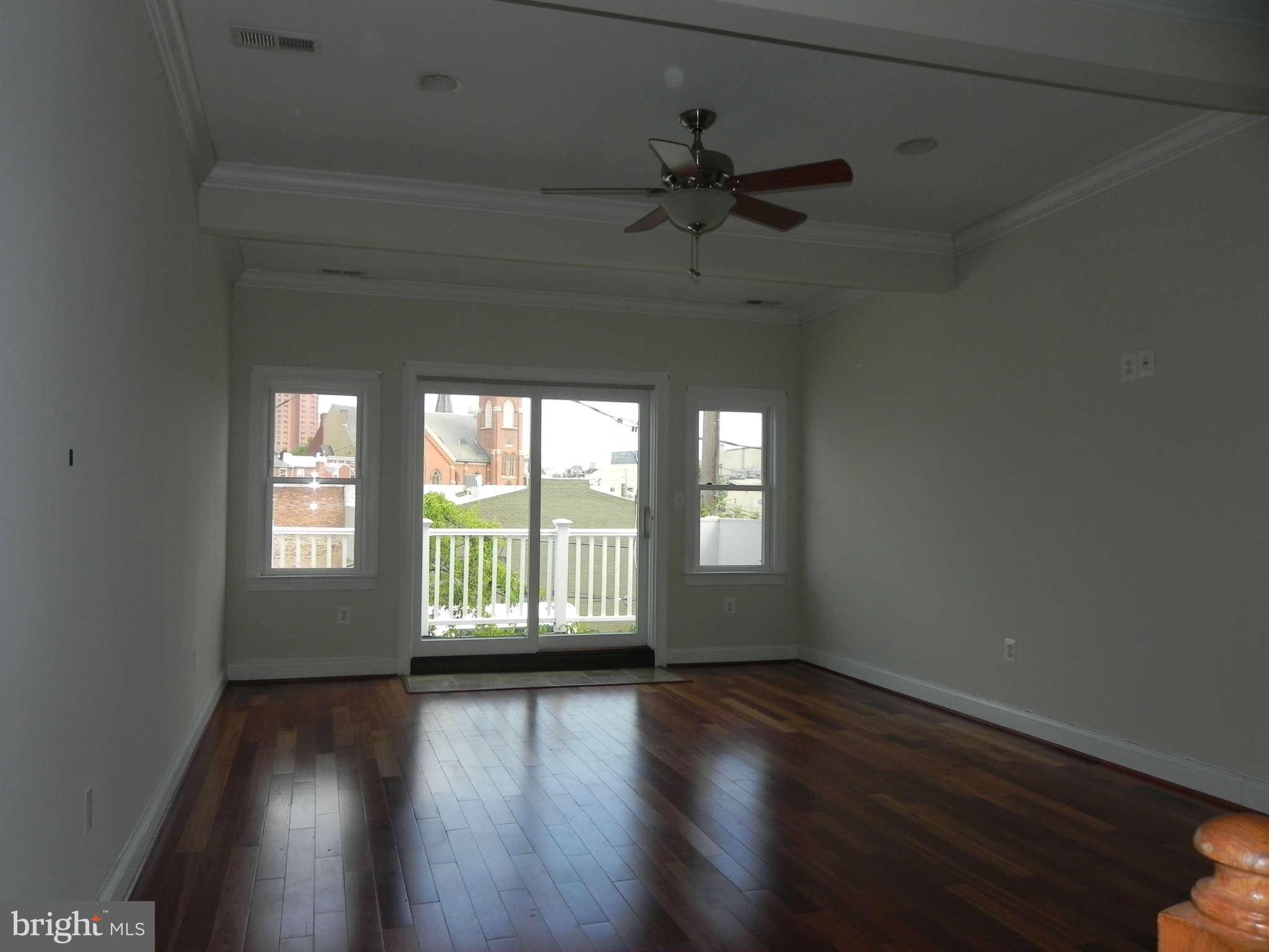 106 West Cross Street Baltimore, MD 21230 - Photo 28 of 29 an empty room with wooden floor and windows