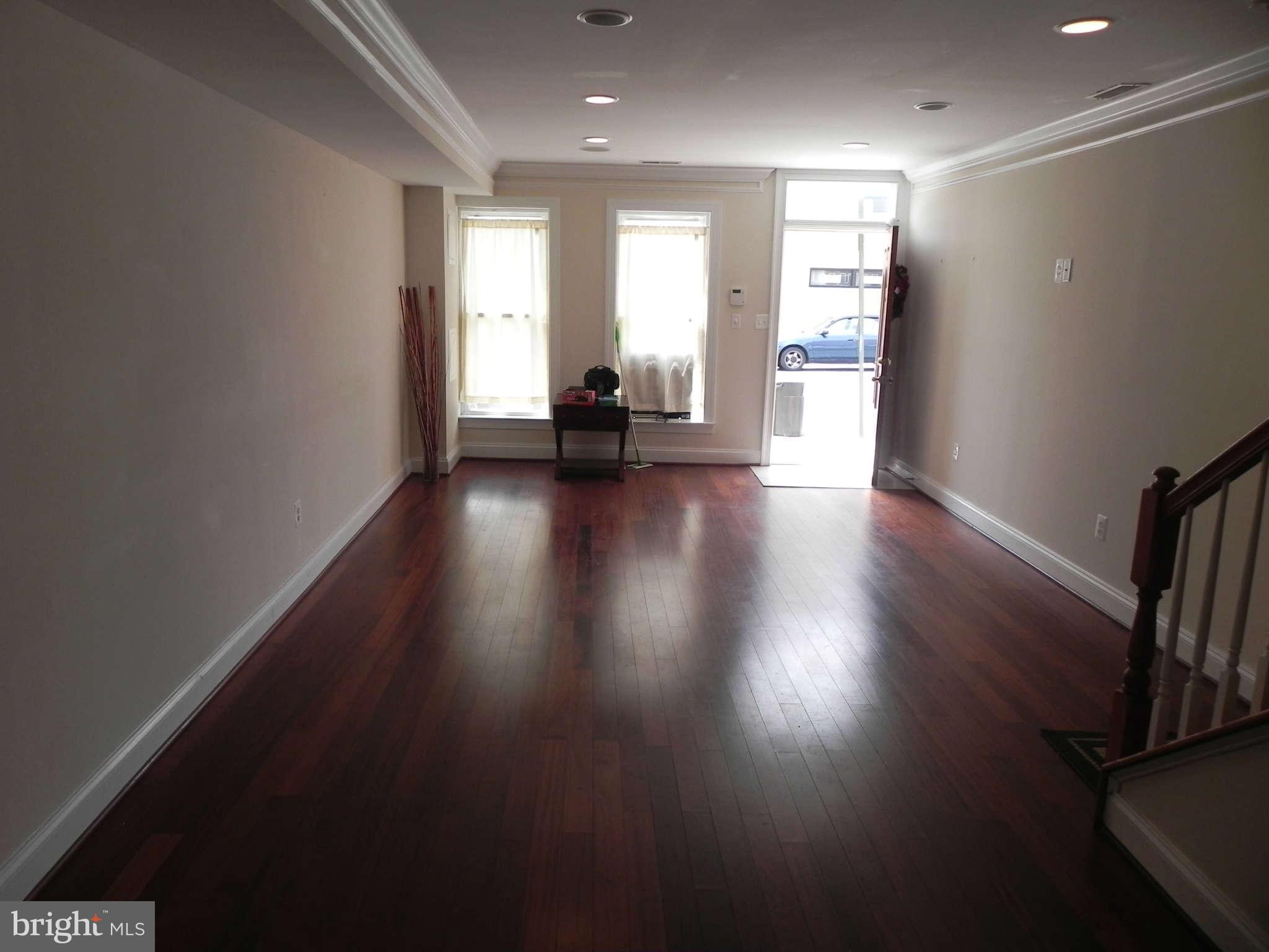 106 West Cross Street Baltimore, MD 21230 - Photo 5 of 29 an empty room with wooden floor and windows
