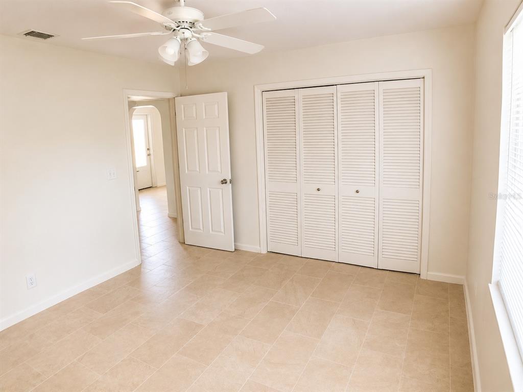 1559 Barry Road Clearwater, FL 33756 - Photo 10 of 20 an empty room with a ceiling fan and a window