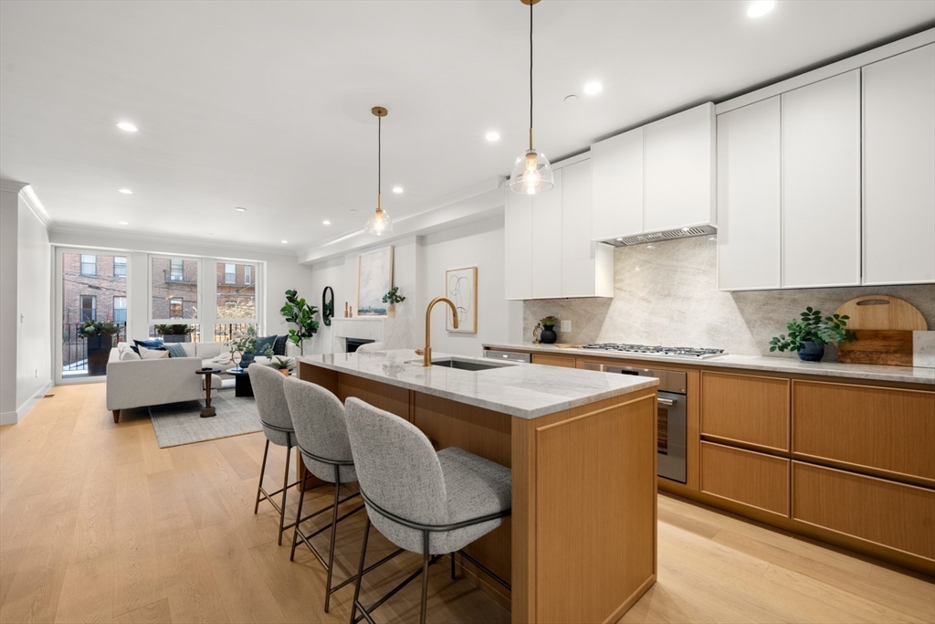 144 Worcester Street, Unit 2 Boston, MA 02118 - Photo 6 of 33 a kitchen with a table chairs stove and white cabinets