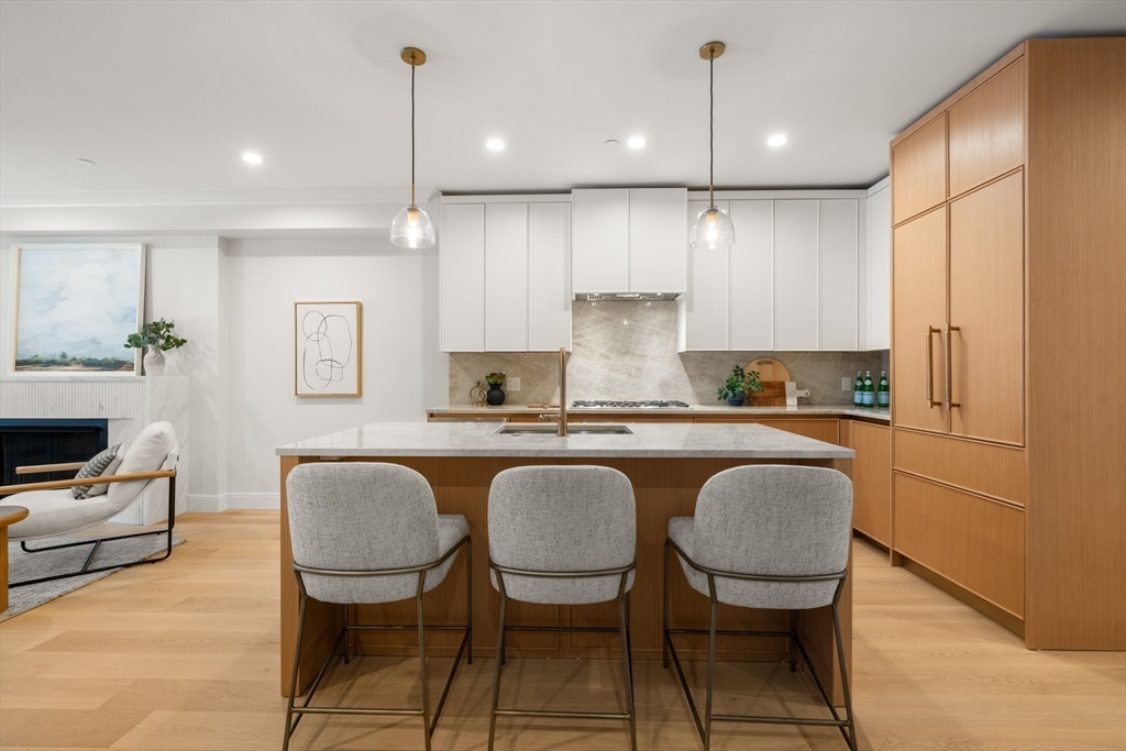 144 Worcester Street, Unit 2 Boston, MA 02118 - Photo 8 of 33 a kitchen with granite countertop wooden cabinets and a dining table