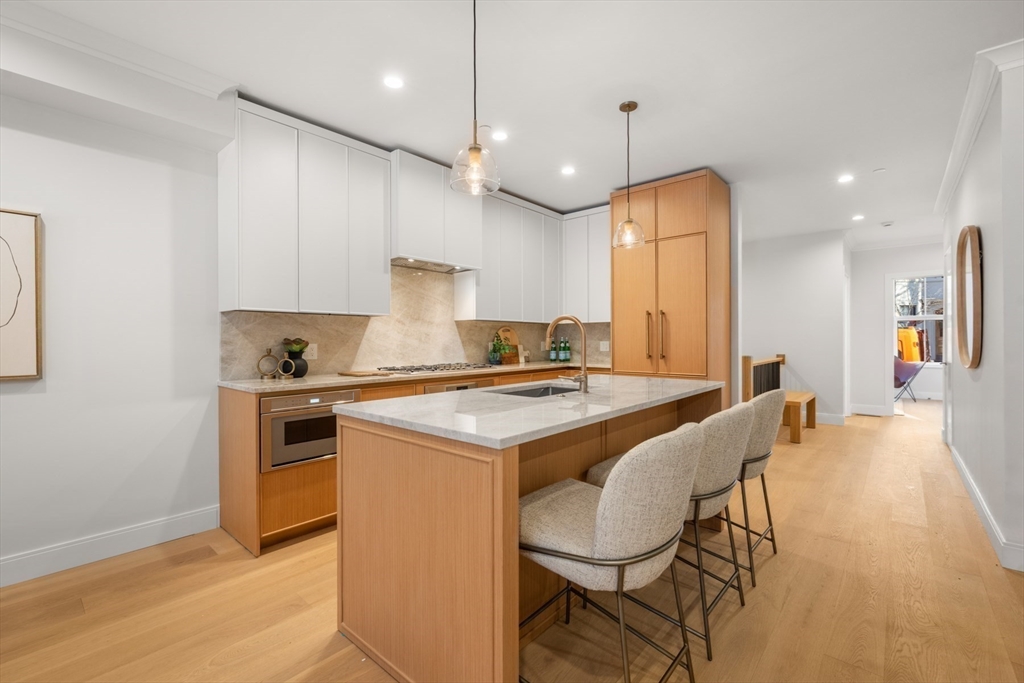 144 Worcester Street, Unit 2 Boston, MA 02118 - Photo 9 of 33 a kitchen with a stove a refrigerator a sink and chairs