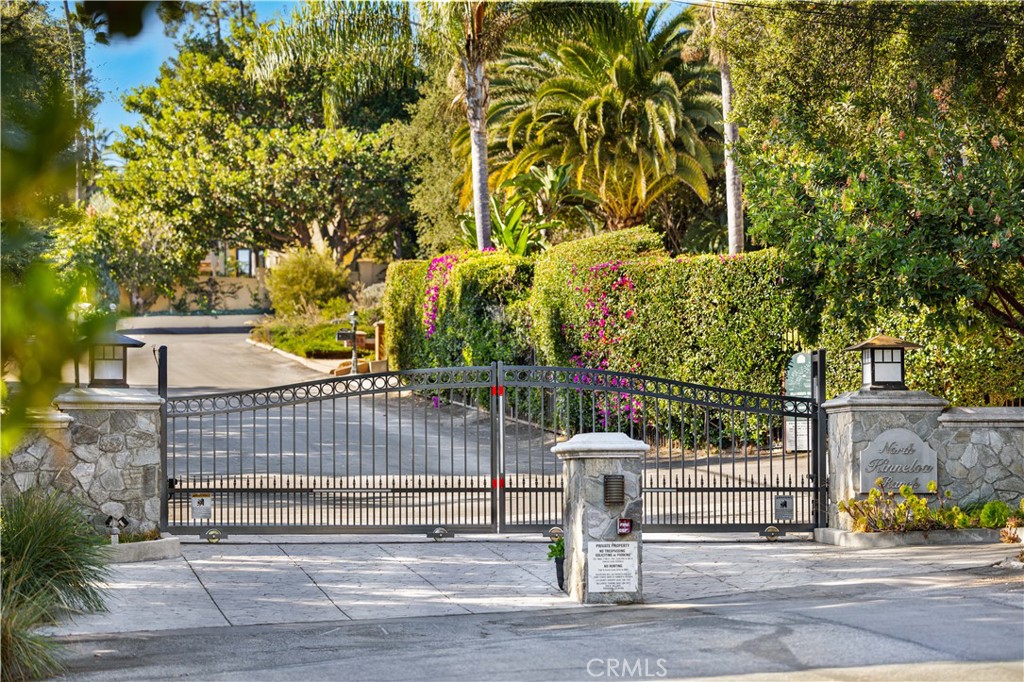 1701 Country Lane Pasadena, CA 91107 - Photo 13 of 14 a view of a brick house with large trees and wooden fence