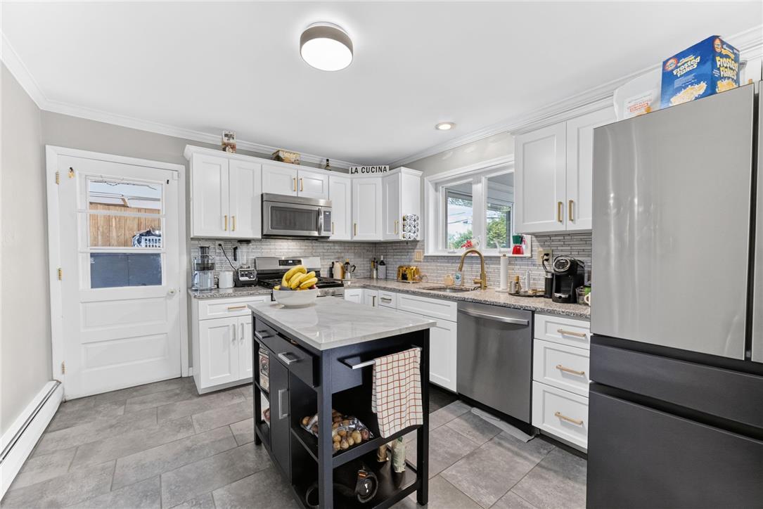 7290 Heather Road Macungie, PA 18062 - Photo 15 of 39 A well-lit kitchen featuring pristine white cabinetry, stainless steel appliances, and a central island.