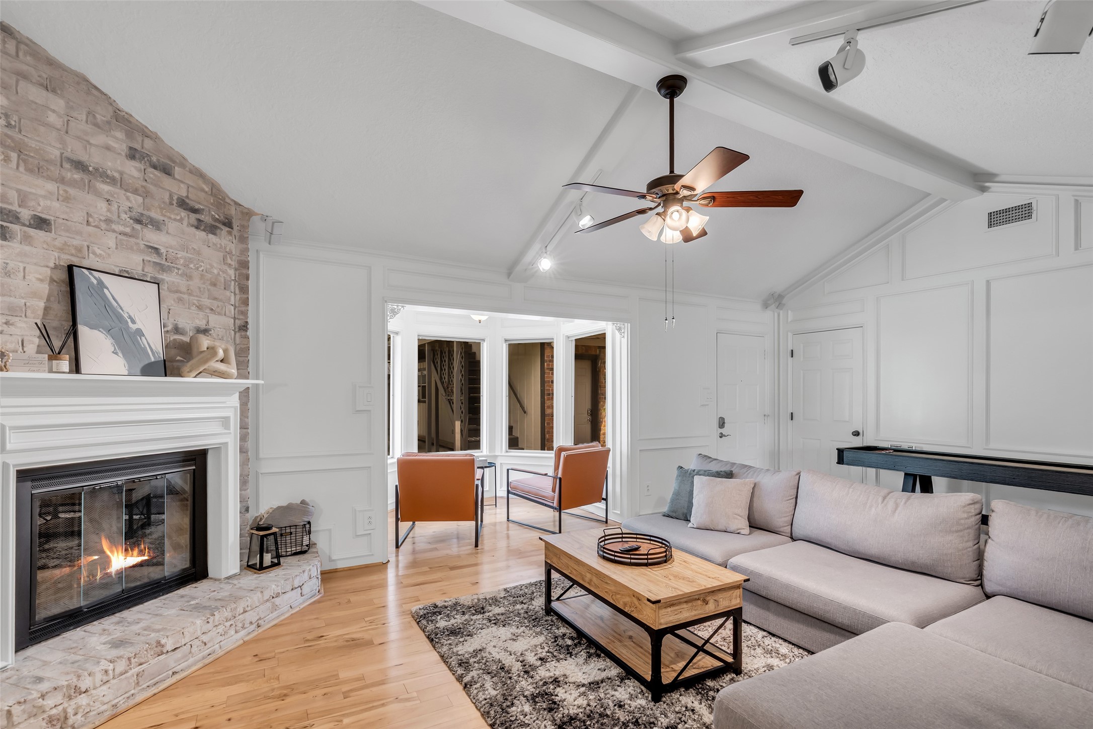 22502 Fields Lane Spring, TX 77389 - Photo 7 of 39 This cozy living room features a vaulted ceiling with exposed beams, a brick fireplace. It opens to a bright area with large windows.