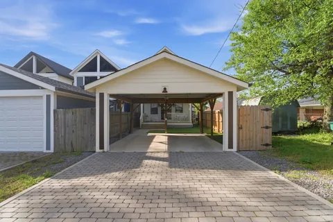 a view of a house with a yard and large tree