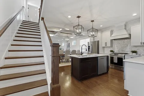 a kitchen with kitchen island granite countertop a sink and a stove