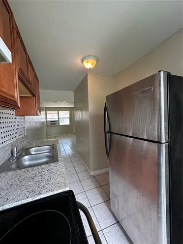 a kitchen with granite countertop a refrigerator and a sink