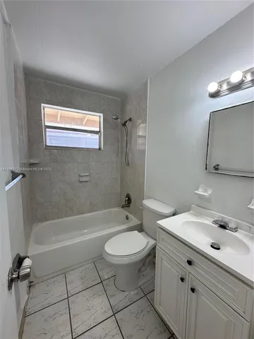 a bathroom with a granite countertop sink a toilet and a bathtub