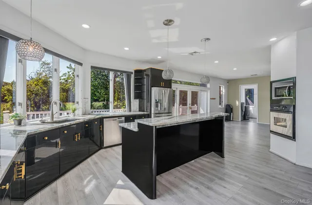 a kitchen with stainless steel appliances granite countertop a sink and wooden cabinets