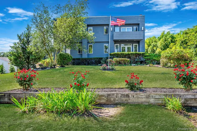 a front view of a house with a yard and a garden