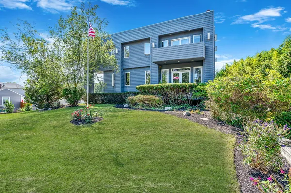 a front view of a house with a yard and trees