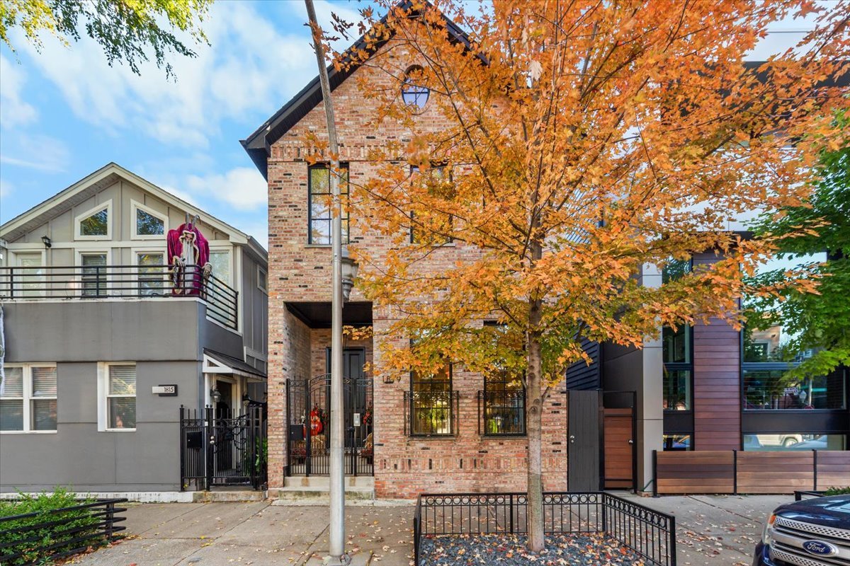 a front view of a house with a tree