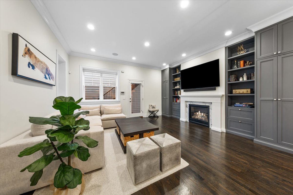 Undisclosed Address Chicago, IL 60622 - Photo 11 of 41 a living room with furniture a fireplace a flat screen tv and a potted plant